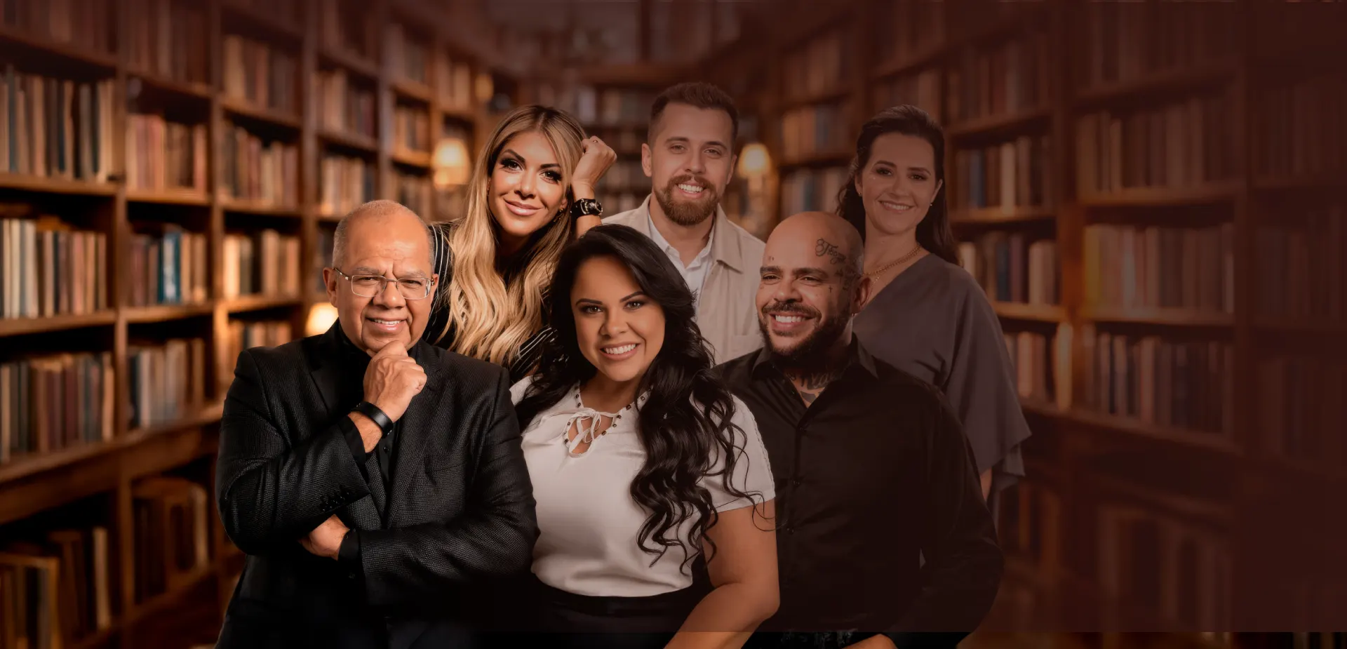Seis autores reunidos entre estantes de uma biblioteca.